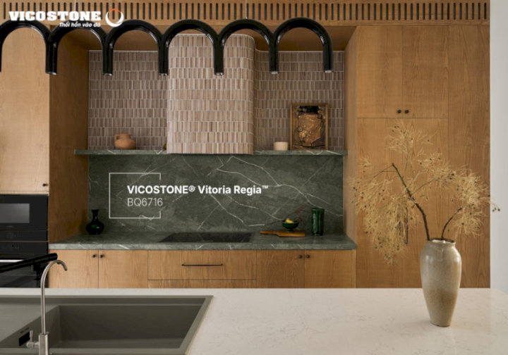 Mảng tường bếp ốp đá VICOSTONE Vitoria Regia BQ6716 nổi bật với những đường vân trắng đan xen trên nền xanh sâu lắng, gợi hình ảnh dòng sông uốn lượn giữa rừng nhiệt đới không chỉ tạo điểm nhấn thẩm mỹ mà còn mang hơi thở thiên nhiên vào không gian sống (Nguồn: Biệt thự hơn 400m² do Nội thất Elemental Design thiết kế)