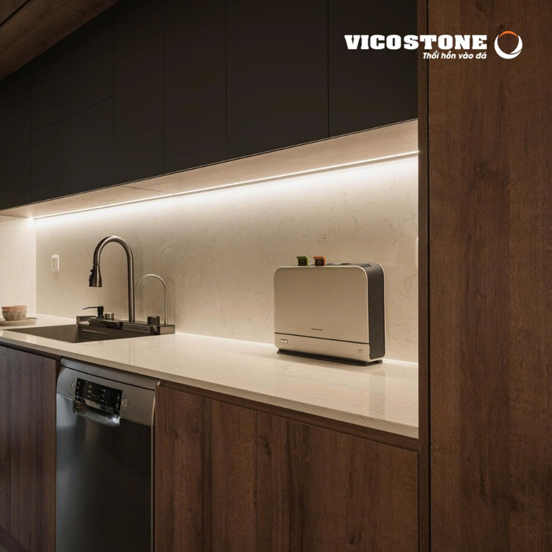 Khu bếp ốp đá VICOSTONE Valley White BQ2600 với nền trắng thanh lịch và đường vân mềm mại, tạo cảm giác rộng thoáng, hiện đại và tinh tế (Nguồn: căn hộ 157m² mang phong cách hiện đại được VIET DESIGN thiết kế).