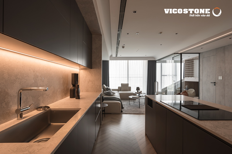 Khu bếp sử dụng đá VICOSTONE Naxos BQ8864 ốp bàn bếp, bàn đảo, tường với hiệu ứng vân mốc độc đáo và sắc xám thanh lịch, tạo nên vẻ đẹp sang trọng, cá tính và đồng bộ cho toàn bộ không gian mở (Nguồn: Căn hộ Duplex 161m² tại Sunshine City (Hà Nội) được kiến trúc nội thất Familia thiết kế).