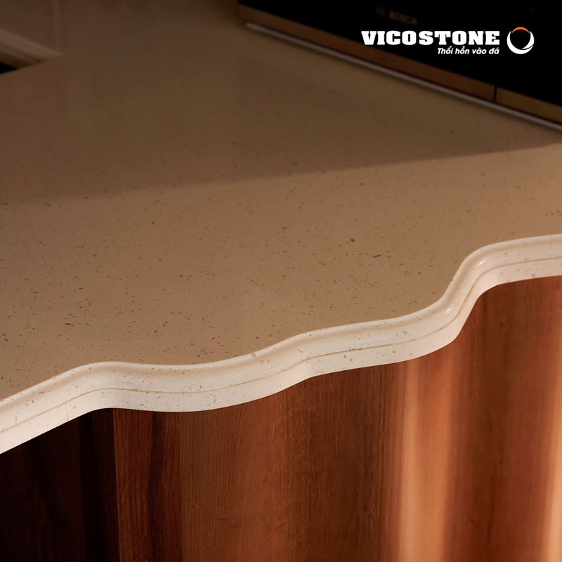 Đá VICOSTONE Crystal Ivory BQ850 được chế tác thành những đường con mềm mại bàn bếp thu hút ánh nhìn (Nguồn: Căn hộ cao cấp tại Lumiere Riverside Thảo Điền (TP.HCM) do Trọn Concept thiết kế và thi công).