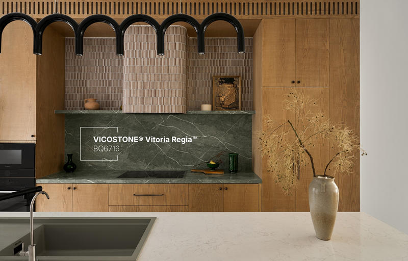 Tường bếp ốp đá VICOSTONE Vitoria Regia BQ6716 với nền xanh xô và đường vân trắng phóng khoáng, tạo nên sự đối lập sống động cùng hệ tủ gỗ sáng và các khung vòm đen, đưa hơi thở thiên nhiên nhiệt đới chảy trọn vào ngôi nhà (Nguồn: biệt thự hơn 400m² do Nội thất Elemental Design thiết kế).