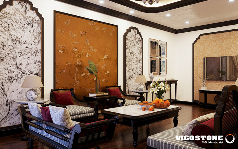 Không gian phòng khách Indochine ấm cúng với điểm nhấn là các mảng tường ốp đá VICOSTONE White Fusion BQ8825 đầy nghệ thuật.