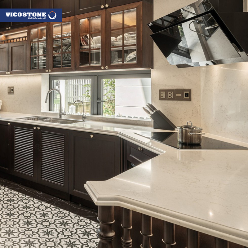 Không gian bếp sang trọng với mặt bàn bếp và tường ốp đá VICOSTONE Misterio BQ8815, kết hợp hài hòa cùng tủ bếp gỗ tối màu và gạch bông hoa văn cổ điển tạo nên vẻ đẹp Indochine hiện đại (Nguồn: Biệt thự song lập Ecopark Ecorivers Hải Dương do kiến trúc sư Ngô Nguyễn Trung từ 3003 Architecture & Interior Design thiết kế).