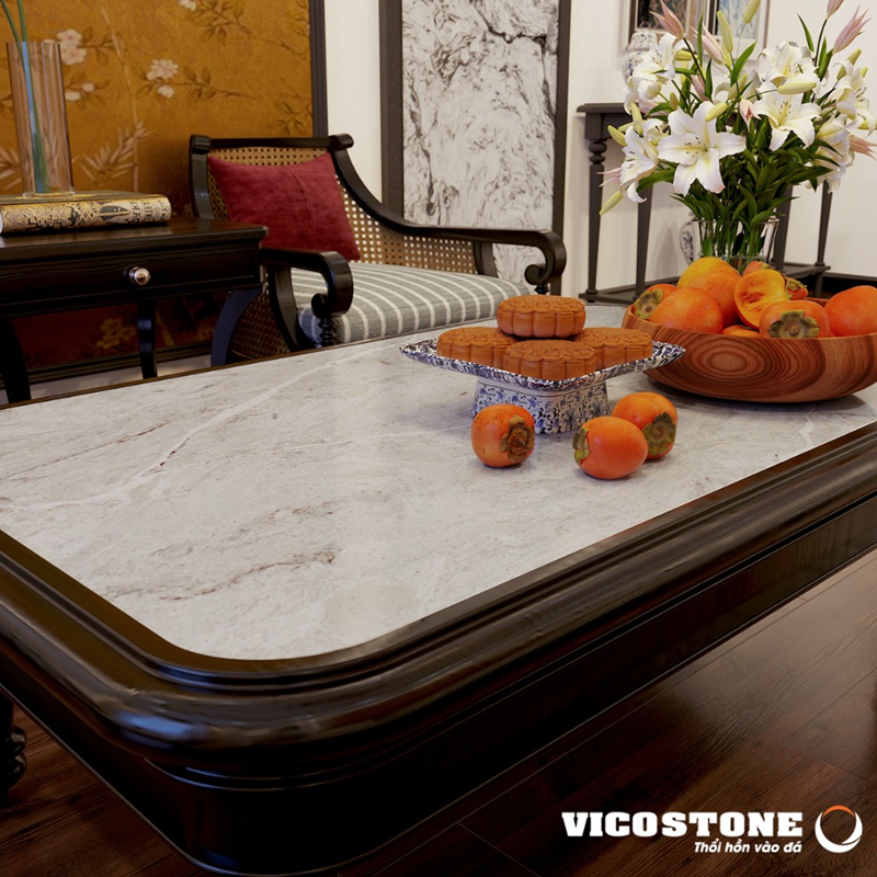 Không gian phòng khách Indochine ấm cúng với điểm nhấn là các mảng tường ốp đá VICOSTONE White Fusion BQ8825 đầy nghệ thuật